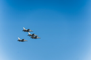 Naklejka na ściany i meble Four fighter planes in airshow on blue sky. Open-air military parade concept. Power of military forces. High quality photo