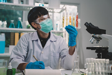 Scientists compare samples of fruit in test tubes in the lab. Is a research and development in beauty medicine and Herb medicine with herbal organic natural in the laboratory.