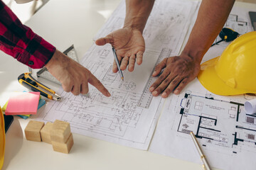 Architect, design engineer working on blueprint planning Group of construction engineers pointing...
