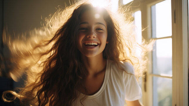 energetic teenager with brown voluminous hair smiling at home, photo of a young girl full of joy of life
