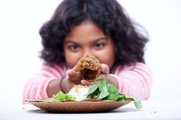 Little girl holding Fried Fish with rice spicy Sauce and vegetable, Indonesian Nasi Uduk Lele goreng