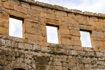 ancient wall of historical building with three windows, old construction on medioeval history outdoor