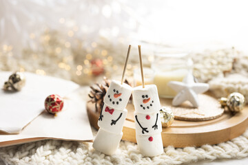 Obraz na płótnie Canvas Christmas background with marshmallow snowmen close-up.
