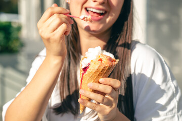 Portrait of happy caucasian brunette woman, eating ice-cream cone.