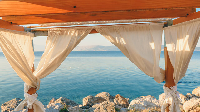 Seaside pergola with curtains in summer morning, travel and holiday background