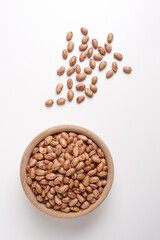 beans inside a wooden bowl on a white background shot from above