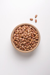 dried beans in wooden bowl on white background shot from above