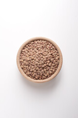 lentils in wooden bowl on white background shot from above