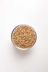 buckwheat in glass bowl on white background shot from above