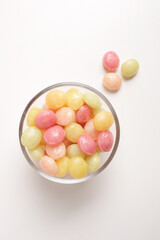 candies in glass bowl on white background shot from above