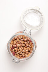 beans borlotti in a glass jar taken from above on a white background