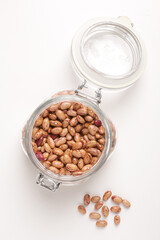 beans borlotti in a glass jar taken from above on a white background