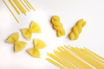 raw pasta of various kinds on white background top view