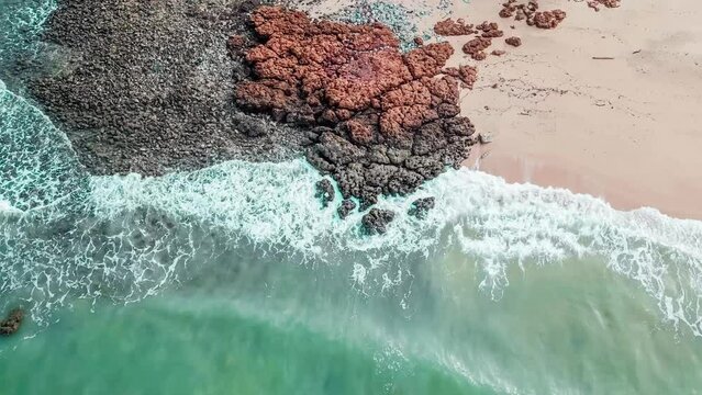 Pictures of the ocean taken by drone.The waves crashing upon the rocks at a beach
