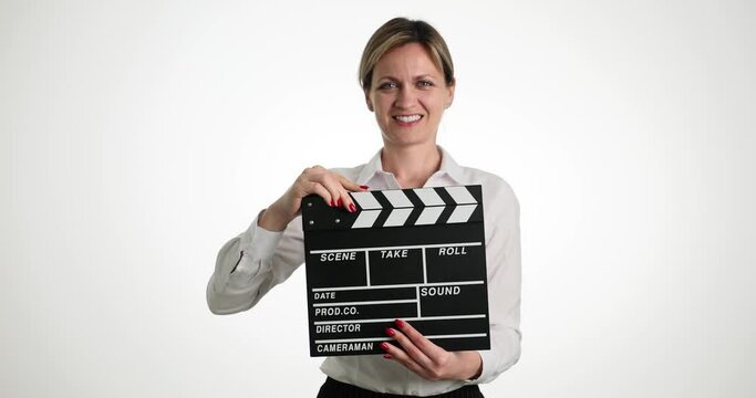 Young woman assistant tapping clapper while filming 4k movie slow motion. Film industry concept