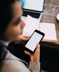 Lady texting on cellphone sitting at table