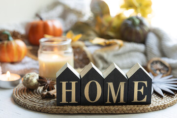 Cozy autumn still life with wooden word Home on a blurred background.