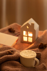 a photo book, a warm sweater, a cup of coffee, a small burning candle, warm, weekend, fall, relaxation, clothes, resting