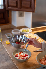 Crop anonymous woman putting olive oil on bread toast while preparing healthy vegan breakfast in home kitchen