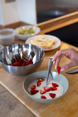 Crop anonymous woman putting olive oil on bread toast while preparing healthy vegan breakfast in home kitchen