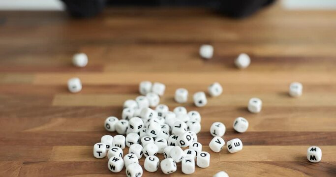 Female hands pouring out cubes with english alphabet closeup 4k movie. Dyslexia and autism concept