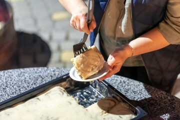 A woman puts cinnabon on a plate at a family party.