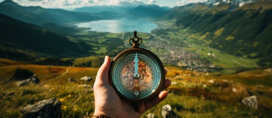 Compass in hand on the background of the mountains and the lake.