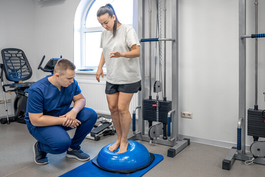 Balance exercise with bosu ball, woman and doctor in gym.
