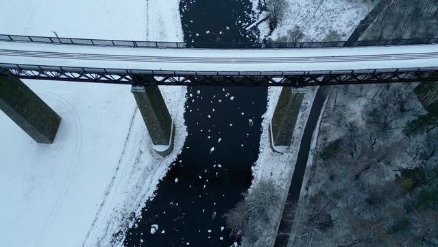 Looking directly down from Findhorn Viaduct icy river and snow covered landscape