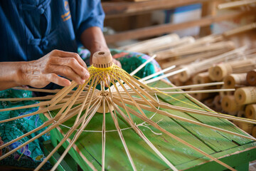 Close-up of the woman's hand is making a paper umbrella, Umbrella making vintage style in Chiang mai, Thailand.