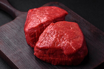 Fresh juicy raw beef medallions with salt and spices