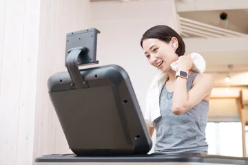 Foto auf Acrylglas Antireflex スポーツジムのランニングマシンで運動する女性（健康・ダイエット） © polkadot