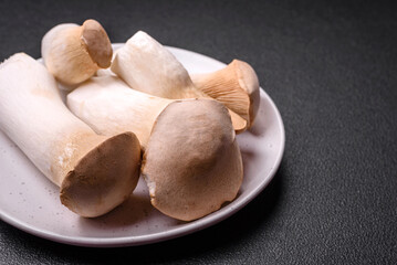 Pleurotus eryngii mushrooms on a dark concrete background