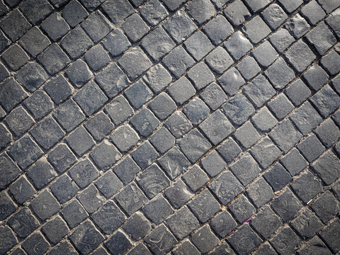 The road is made of neatly arranged square-shaped stones.