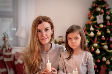 Obraz na płótnie Canvas クリスマスにキャンドルを持つ母と娘