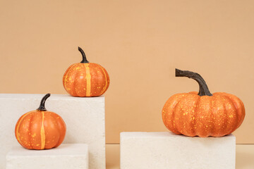 Pumpkin on a stone podium pedestal, showcase for product presentation. Autumn product promotion. Beige background with Halloween pumpkin.