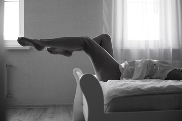Sexy slender female legs on white bed. Sports and Care Concept.