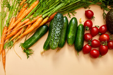 Flat lay vegetables, carrots, cucumbers, avocados, tomatoes on the biege background, grocery concept, Healthy food