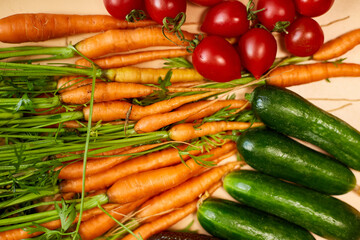 Flat lay vegetables, carrots, cucumbers, avocados, tomatoes on the biege background, grocery concept, Healthy food