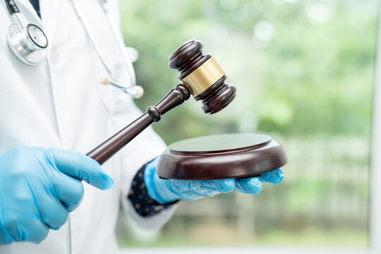 Doctor holding judge gavel, forensic medicine, medical law and crime justice concept.