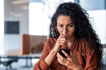 Upset and disappointed woman reading bad news close up, businesswoman inside office at workplace...