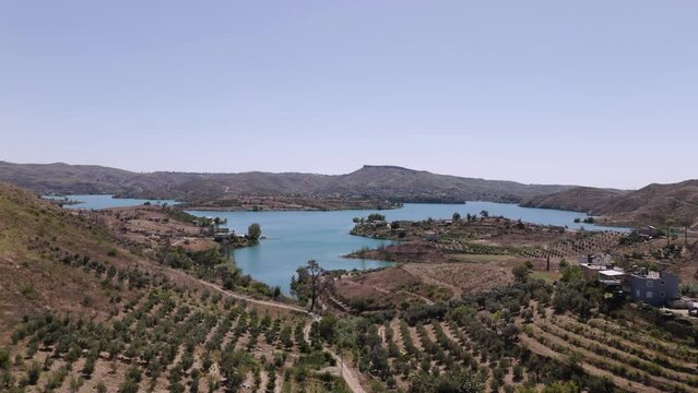 Flying over rows of trees towards Green lake turquoise waters in the valley of the Taurus mountains in Turkey