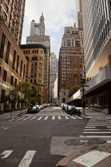 cars parked on wide roadway near modern and vintage budlings in new york city, urban landscape