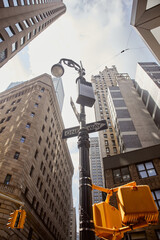 low angle view of street pole with road signs and traffic lights near tall building in new york city