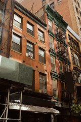 Fototapeta na wymiar red brick building with fire escape stairs in downtown of new york city, urban architecture