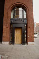 entrance of brick building with portico and arch window in downtown of new york, urban architecture