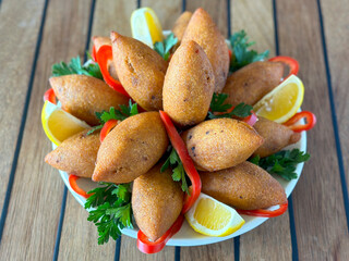 Stuffed meatballs. Kibbeh or Stuffed meatballs on wood background. Middle Eastern cuisine flavors. local name icli kofte