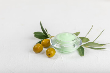 Jar of natural olive cream with olive oil extract on a texture background. Cosmetic tube. Moisturizing cosmetic cream for skin. Body care. Beauty concept. Copy space. Flat lay. Hand cream.