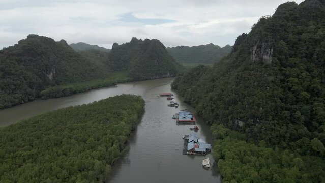 Beautiful eco tourism location on tropical river in shadow of tall mtn