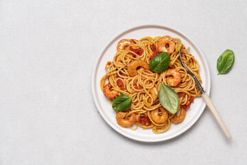 Shrimp marinara sauce pasta in plate on white background with copy space. Seafood spaghetti, Mediterranean cuisine